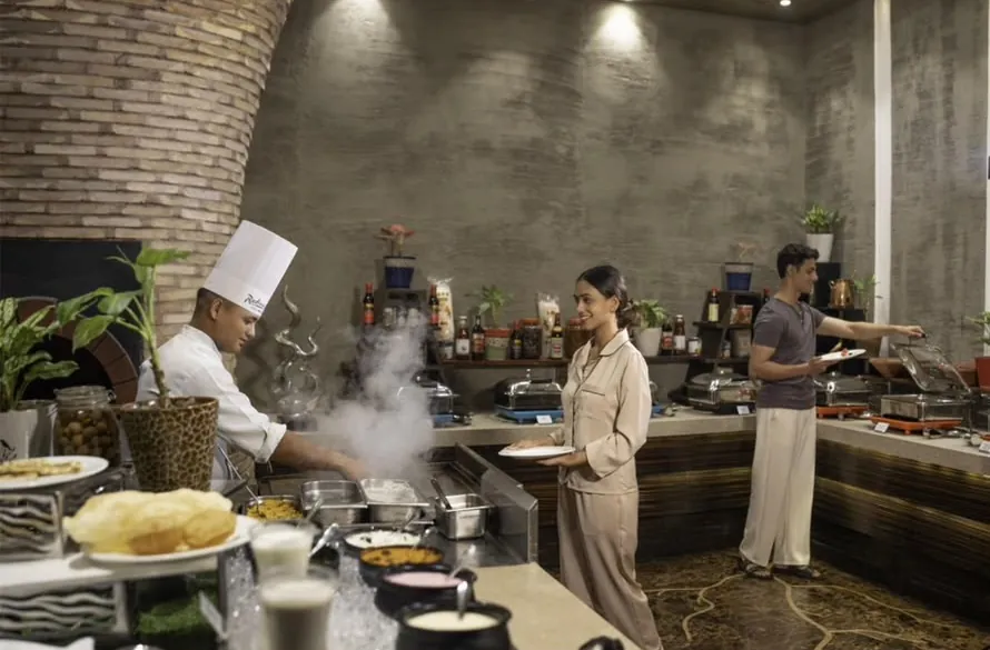 Aanchal at the breakfast buffet with a chef at the live counter