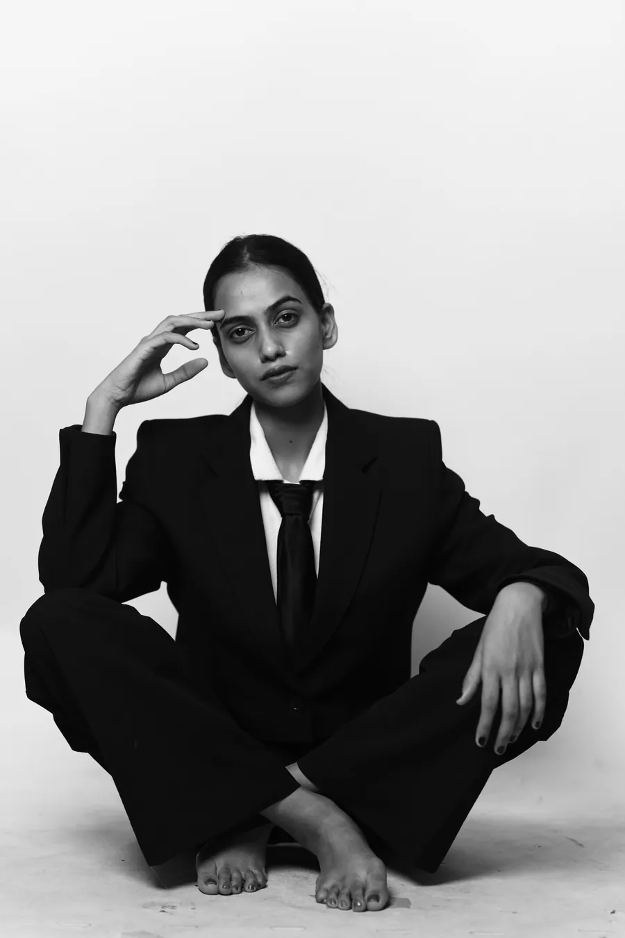 Black and white photo of Aanchal seated in a black suit